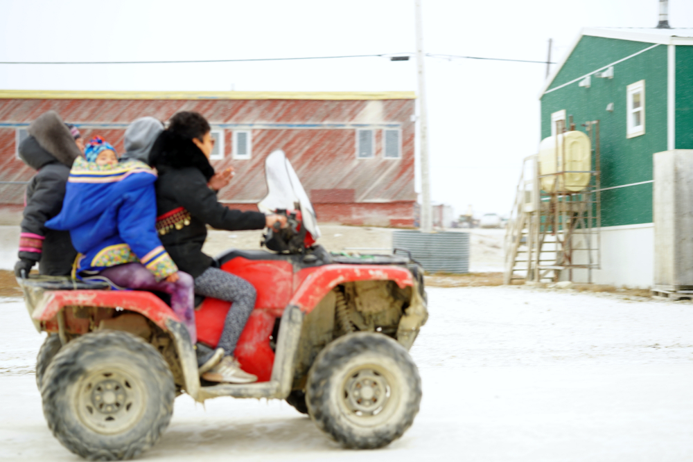 Eine Inuit-Familie: Mutter, Tochter, Säugling 
			und Sohn auf einem der typischen Quads, die den ganzen Tag durch Igloolik kurven.